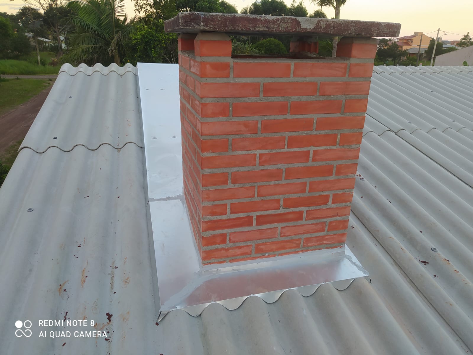 Chaminé de tijolos com vedação metálica instalada no telhado