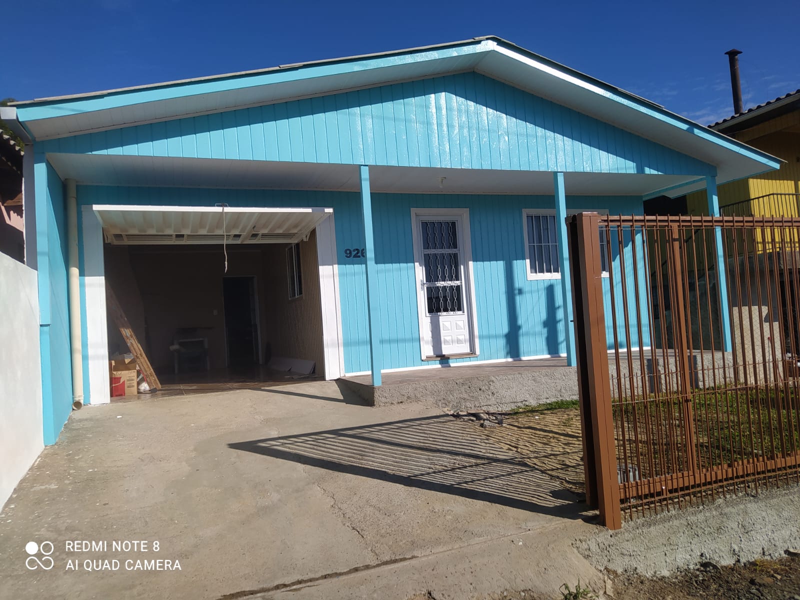 Fachada residencial em madeira pintada em azul e branco